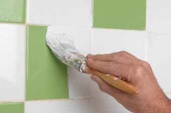 Нанесение краски на керамическую плиту с помощью кисточки клей для плитки в ванную